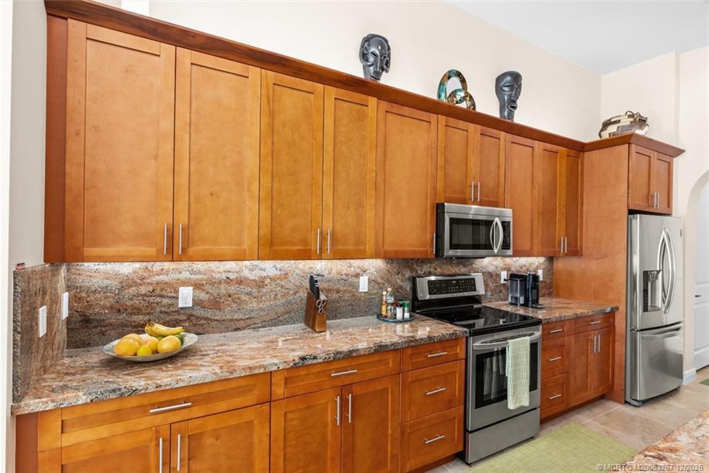 4940 Southeast Inlet Isle Way Stuart, FL 34997 - Photo 18 of 75 a kitchen with a sink a stove and cabinets