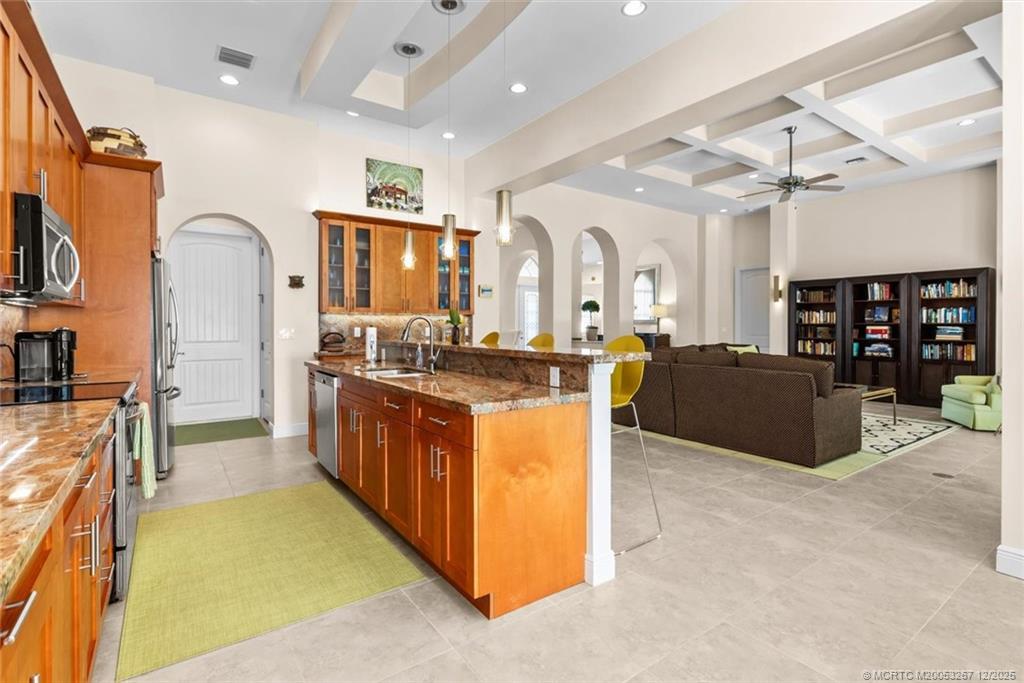 4940 Southeast Inlet Isle Way Stuart, FL 34997 - Photo 20 of 75 a large kitchen with stainless steel appliances kitchen island granite countertop a refrigerator and a stove