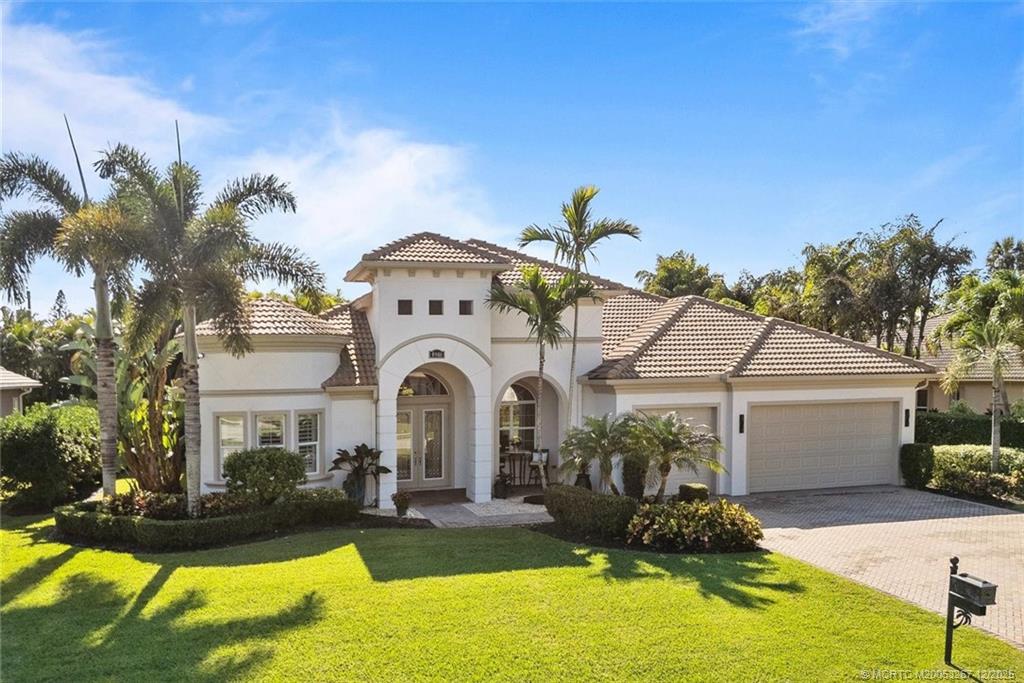 4940 Southeast Inlet Isle Way Stuart, FL 34997 - Photo 2 of 75 a front view of a house with garden