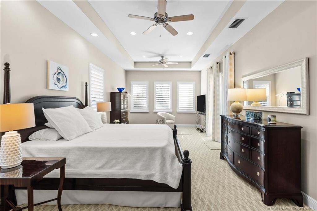 4940 Southeast Inlet Isle Way Stuart, FL 34997 - Photo 28 of 75 a large bedroom with a bed dresser and a dining table