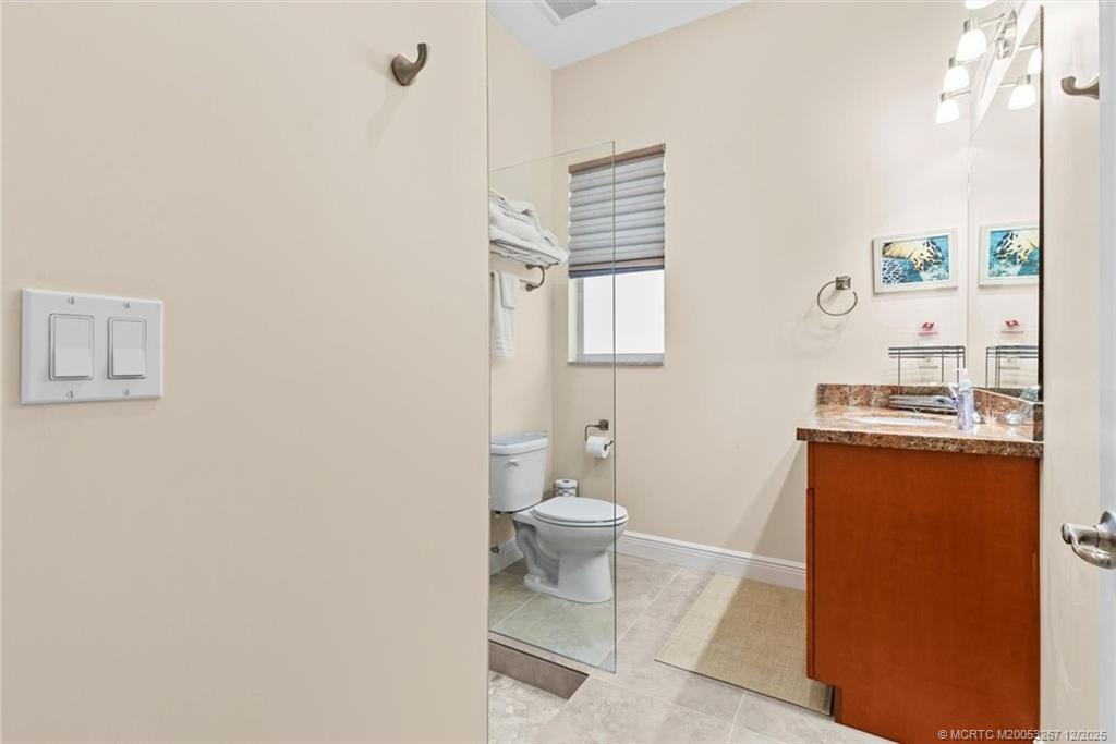4940 Southeast Inlet Isle Way Stuart, FL 34997 - Photo 38 of 75 a bathroom with a toilet a sink and mirror