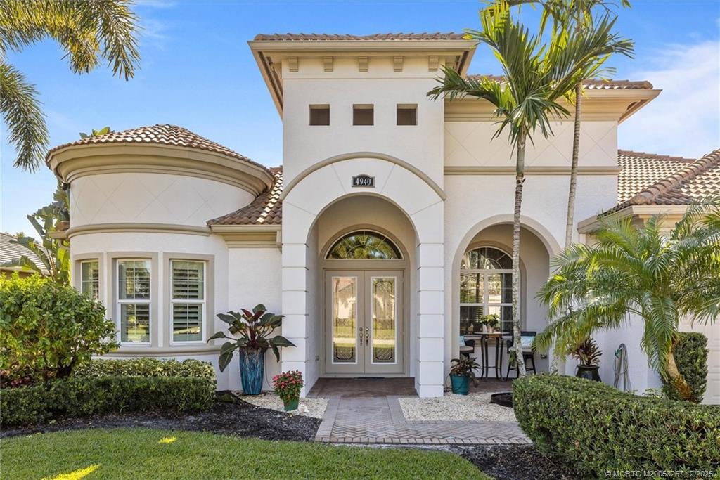 4940 Southeast Inlet Isle Way Stuart, FL 34997 - Photo 4 of 75 a front view of a house with a garden