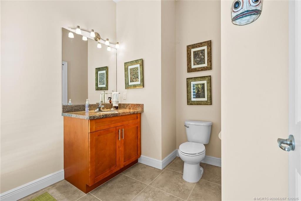 4940 Southeast Inlet Isle Way Stuart, FL 34997 - Photo 44 of 75 a spacious bathroom with a granite countertop sink toilet a large mirror and shower