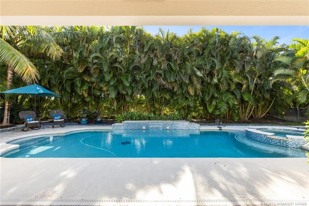 4940 Southeast Inlet Isle Way Stuart, FL 34997 - Photo 47 of 75 a view of a swimming pool with an outdoor space and seating area