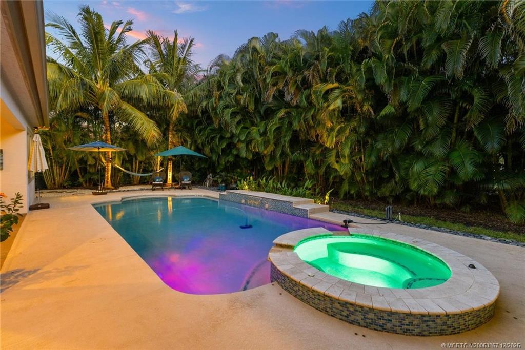 4940 Southeast Inlet Isle Way Stuart, FL 34997 - Photo 49 of 75 a view of a swimming pool with a chairs and tables