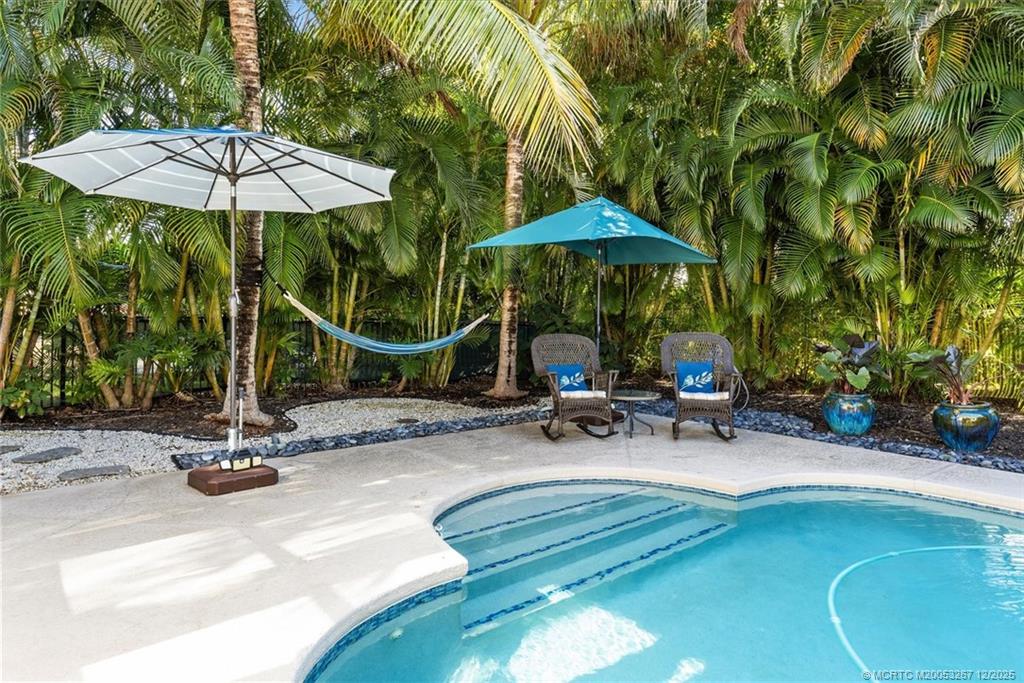 4940 Southeast Inlet Isle Way Stuart, FL 34997 - Photo 50 of 75 a view of a chairs and table under an umbrella in the patio