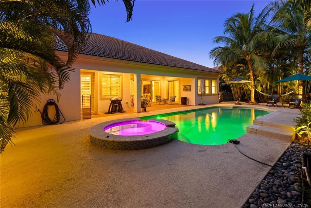 4940 Southeast Inlet Isle Way Stuart, FL 34997 - Photo 56 of 75 a view of a swimming pool with a yard table and chairs