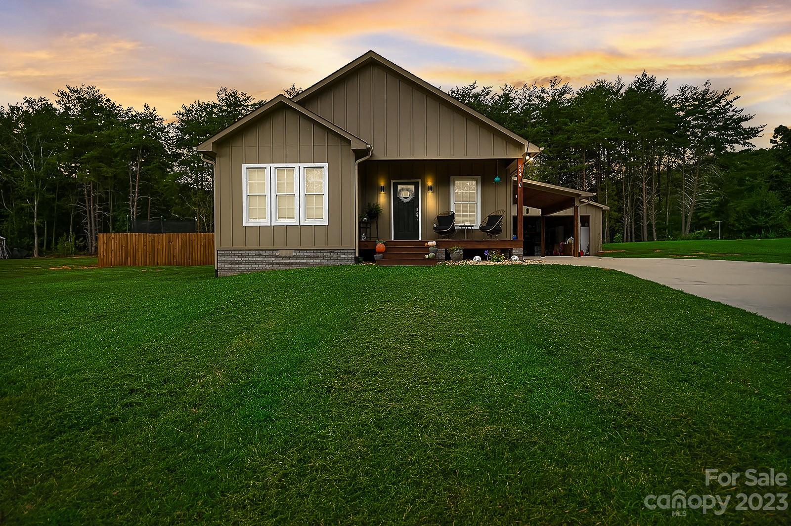 a view of a house with a yard and sitting area