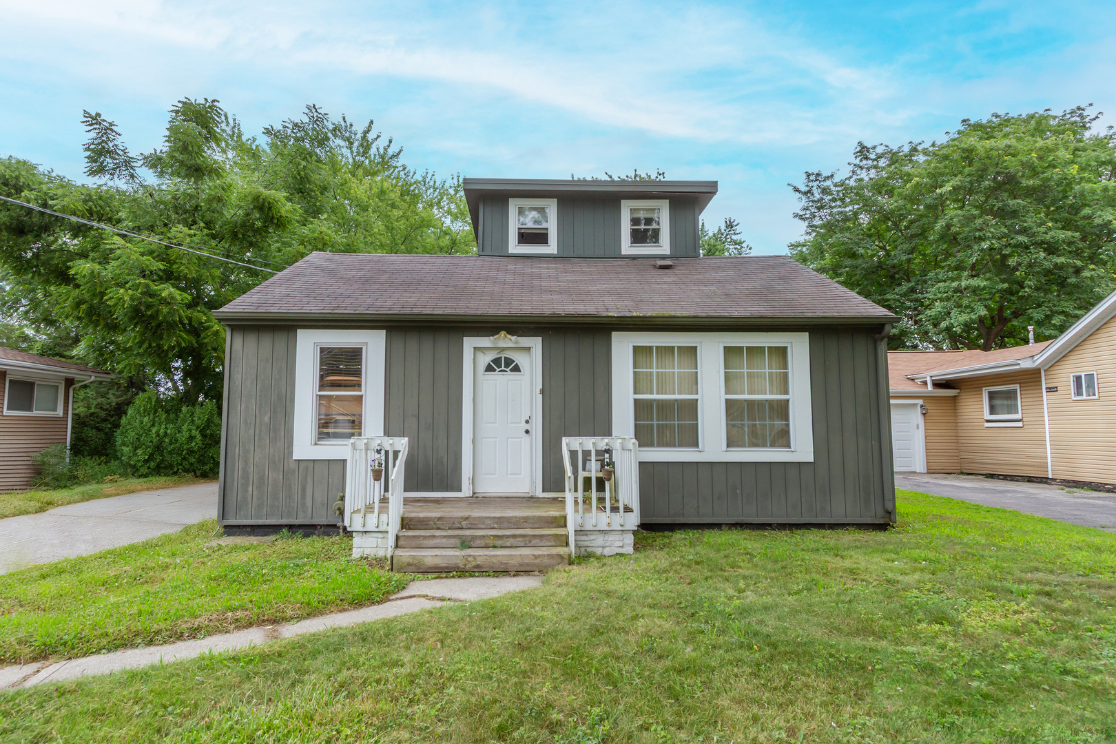 a view of a house with a yard and a large tree