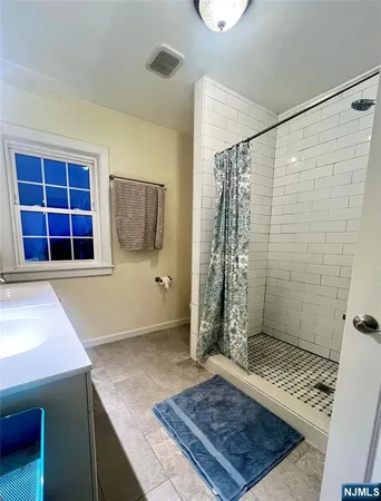a view of an empty room with a rug and a window