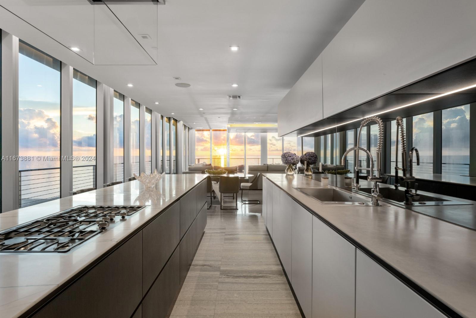 3651 Collins Avenue, Unit 800 Miami Beach, FL 33140 - Photo 4 of 33 a large kitchen with kitchen island a large window a sink stainless steel appliances and cabinets
