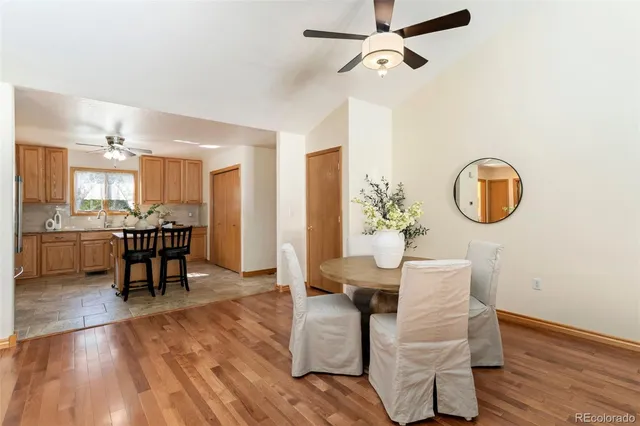 a dining room with wooden floor a chandelier a wooden table and chairs