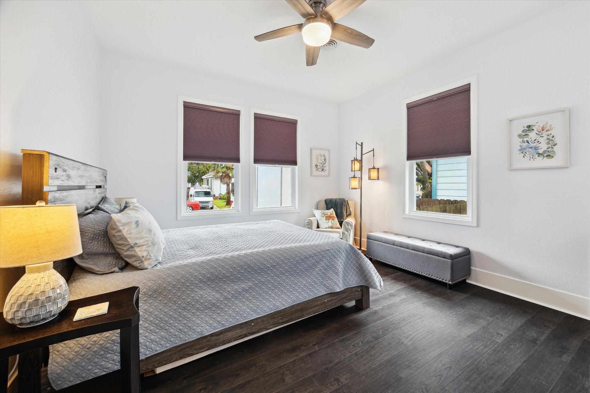 4109 Avenue R Galveston, TX 77550 - Photo 11 of 18 Discover the charm of this additional bedroom, featuring elegant wood flooring and abundant natural light from large windows.