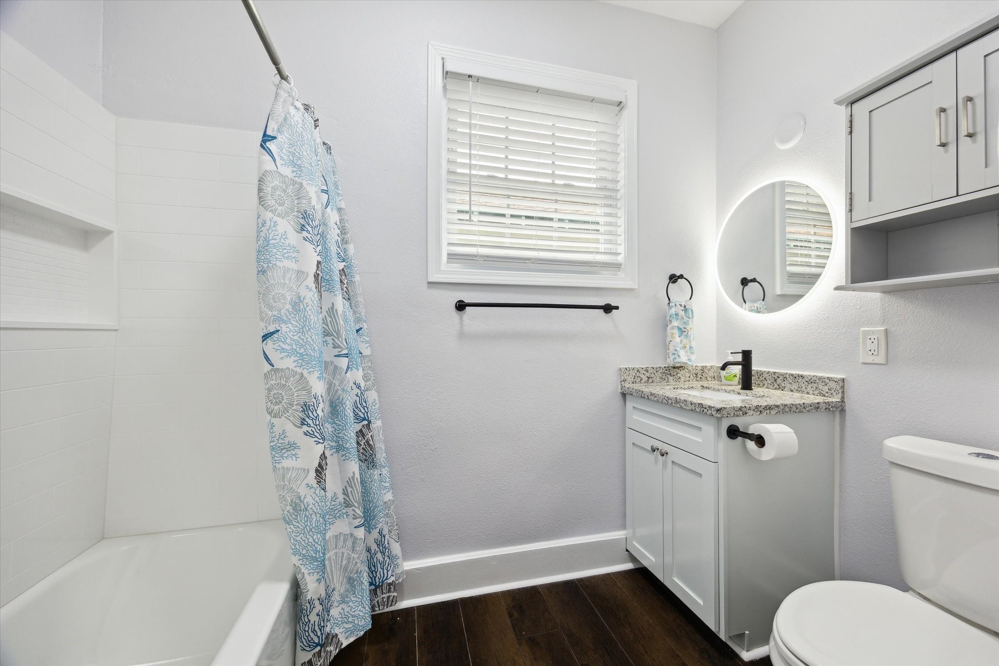 4109 Avenue R Galveston, TX 77550 - Photo 13 of 18 This updated guest bathroom boasts a stylish shower/tub combo and a modern backlit mirror above the vanity.