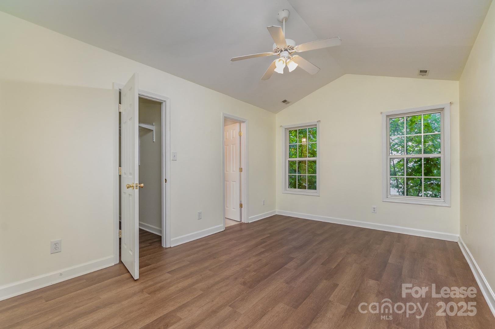 2716 Rabbit Ridge Drive Bessemer City, NC 28016 - Photo 7 of 15 an empty room with wooden floor chandelier fan and windows