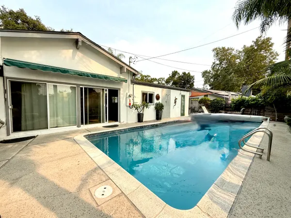 a view of a white house with a swimming pool