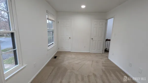 a view of hallway with a window and a bathroom