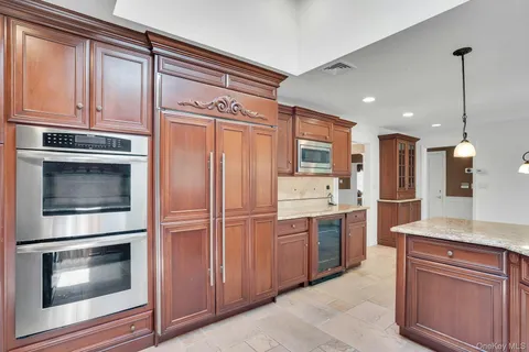 a kitchen with stainless steel appliances granite countertop a refrigerator and a stove top oven