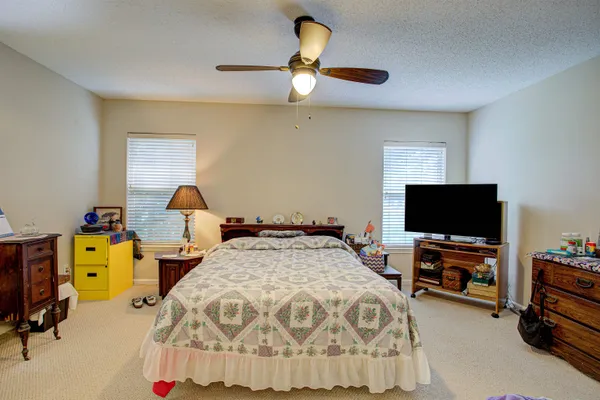 a bedroom with a bed and a flat tv screen on the dresser