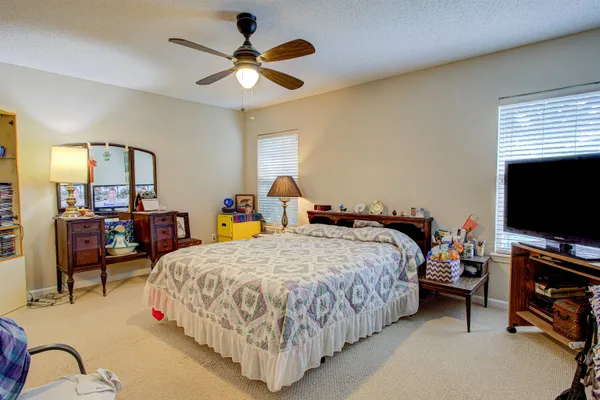 a bedroom with bed and a flat tv screen on dresser