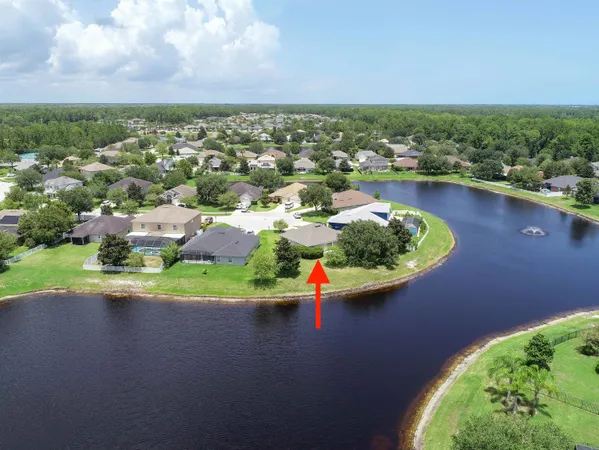 an aerial view of a house with a garden and lake view