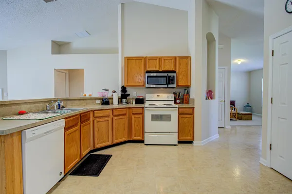 a kitchen with white cabinets and appliances