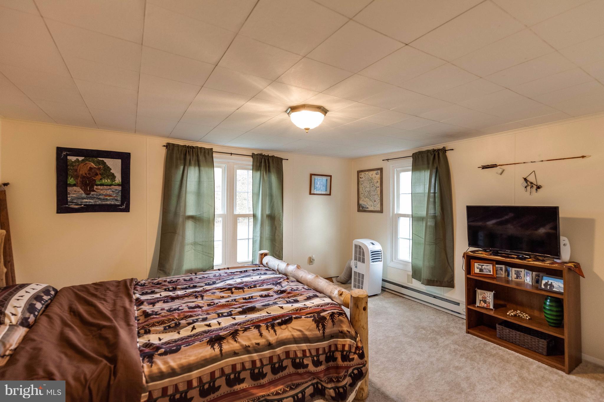 25453 Highfield Road Cascade, MD 21719 - Photo 25 of 30 a bedroom with a bed and a flat screen tv