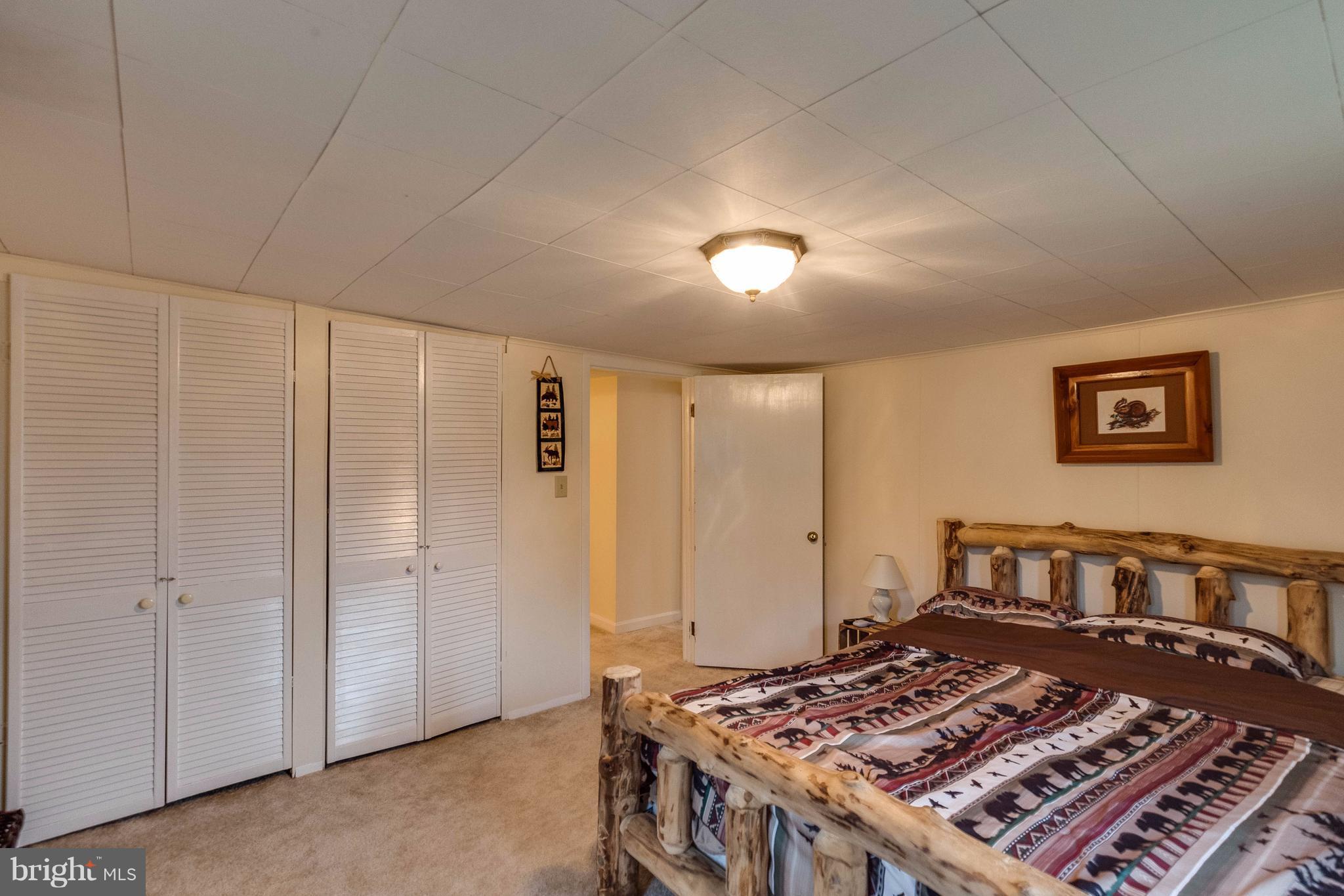 25453 Highfield Road Cascade, MD 21719 - Photo 26 of 30 a bed sitting in a spacious bedroom next to a cabinet