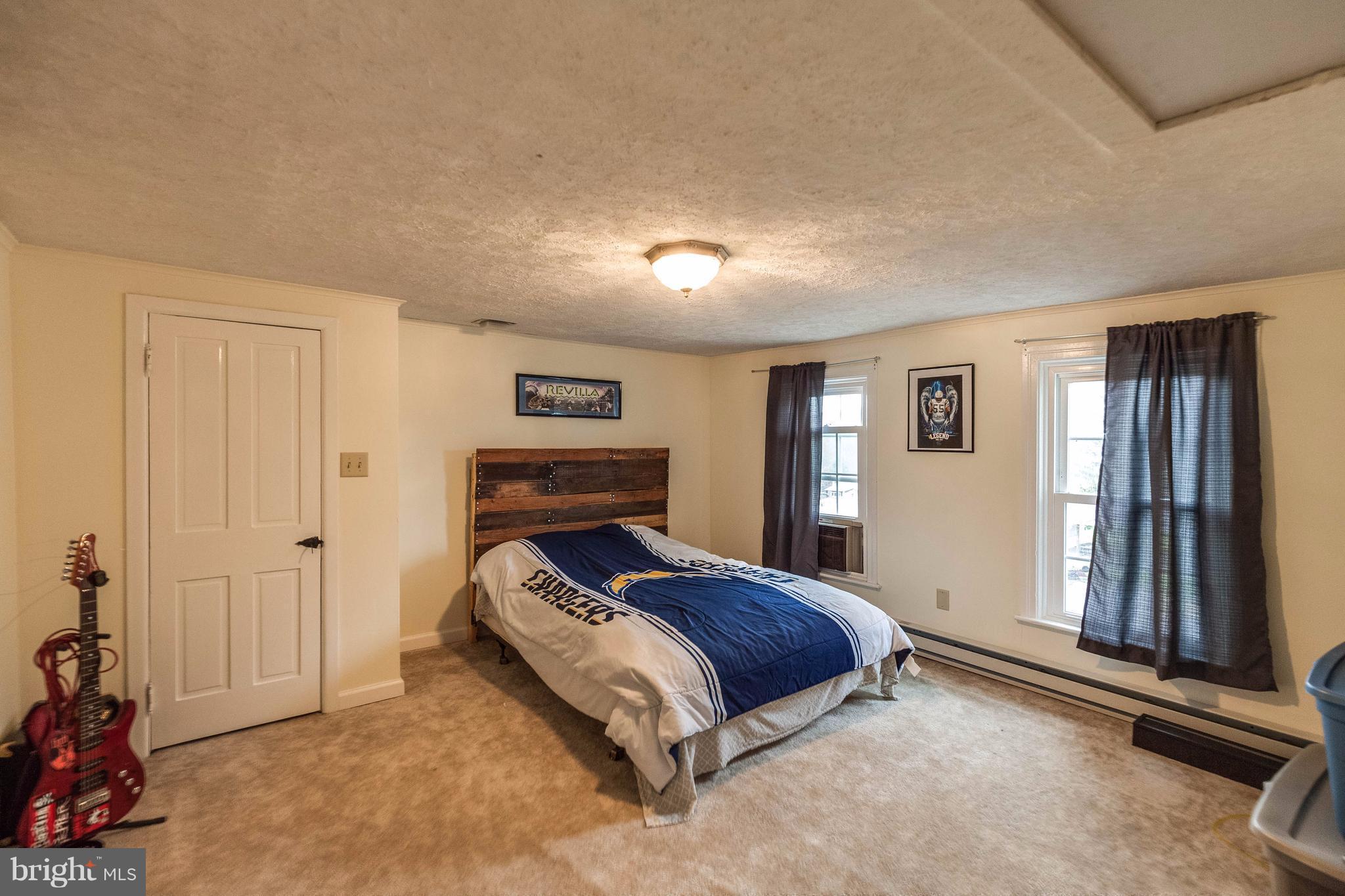 25453 Highfield Road Cascade, MD 21719 - Photo 28 of 30 a bed sitting in a spacious bedroom next to a window and a livingroom