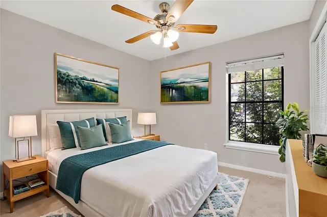 a bedroom with a large bed a chandelier and a window