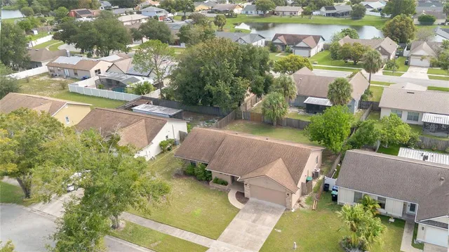 an aerial view of a house with a garden and lake view