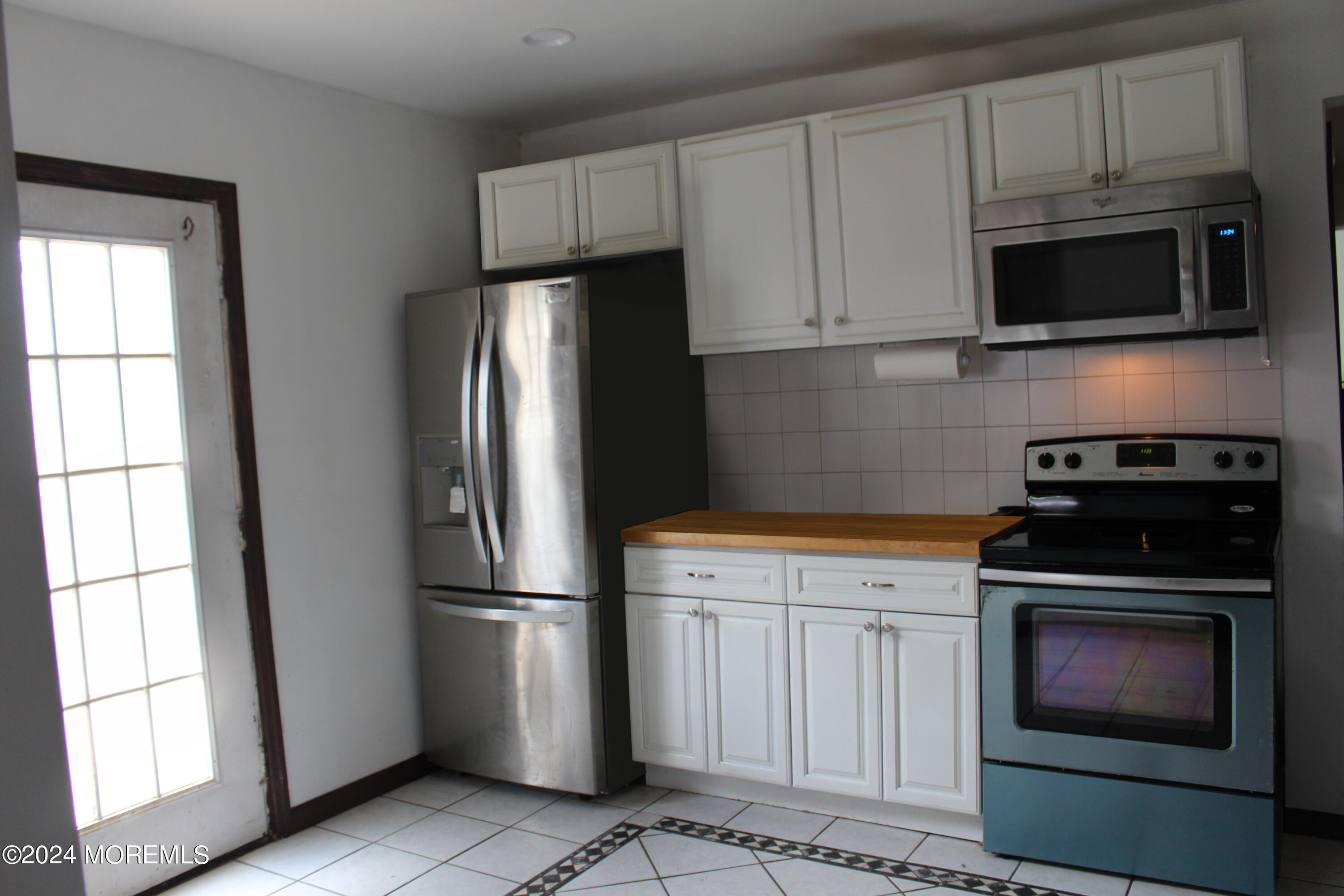 46 Toms River Road Jackson, NJ 08527 - Photo 8 of 16 a kitchen with stainless steel appliances white cabinets white stove a microwave and a refrigerator