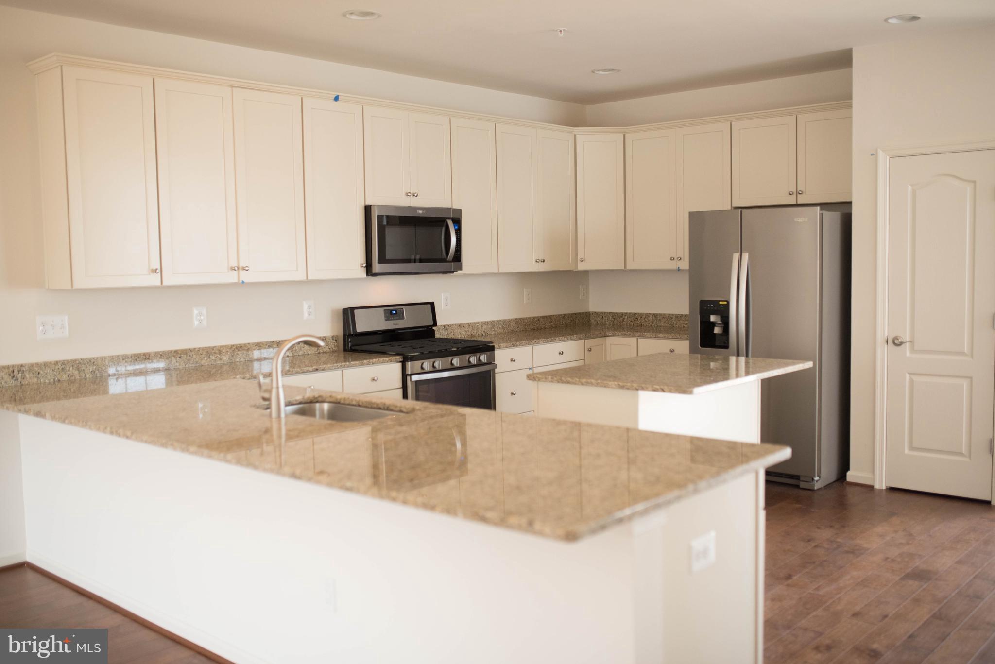 919 Morgan Run Road Baltimore, MD 21220 - Photo 3 of 16 a kitchen with granite countertop a refrigerator sink and white cabinets