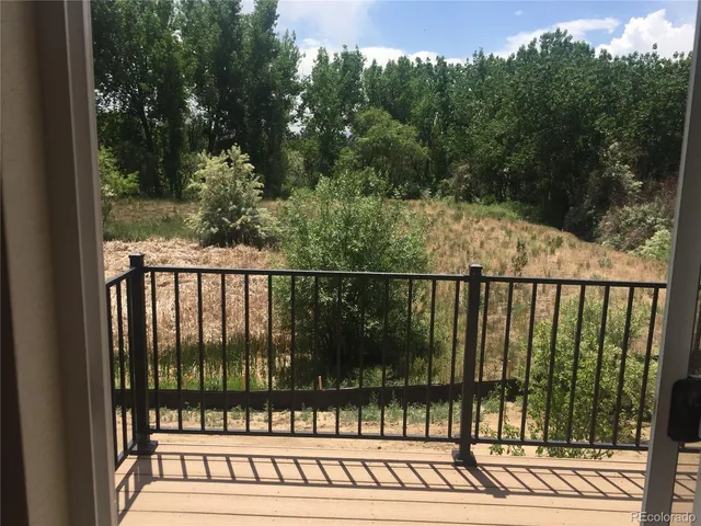 a view of balcony with wooden floor and fence