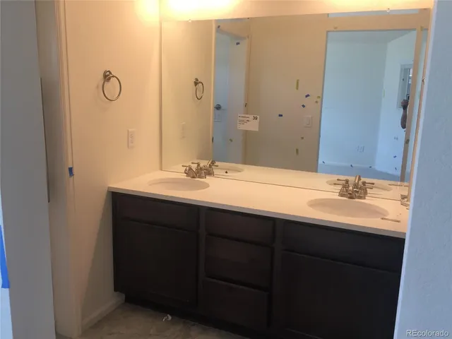 a bathroom with a double vanity sink and a mirror