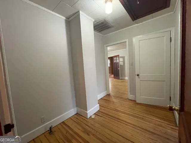 a view of an empty room with wooden floor