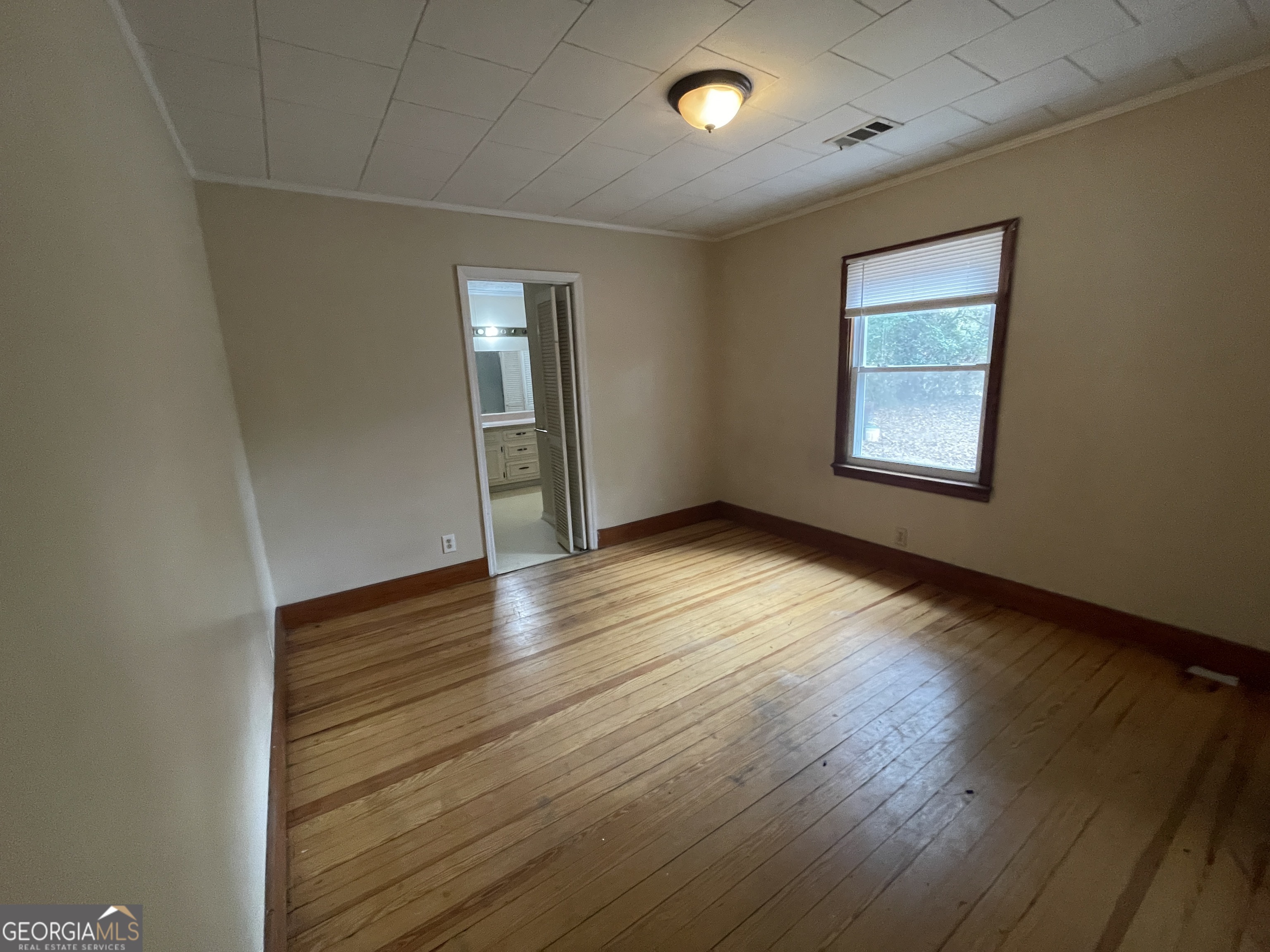 104 4th Street Cochran, GA 31014 - Photo 24 of 41 an empty room with wooden floor and windows