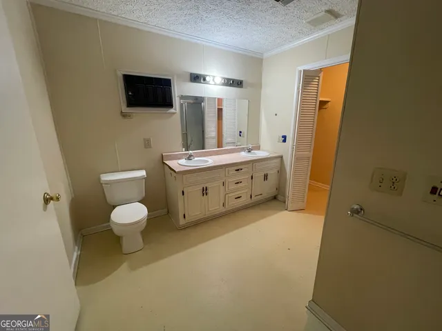 a bathroom with a granite countertop toilet sink and mirror