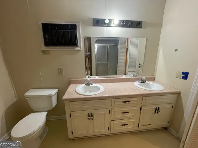 a bathroom with a toilet a sink and mirror