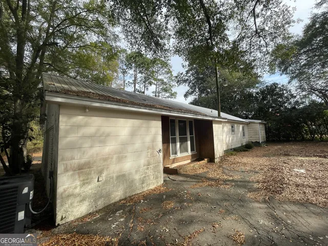 a view of a small house with large tree