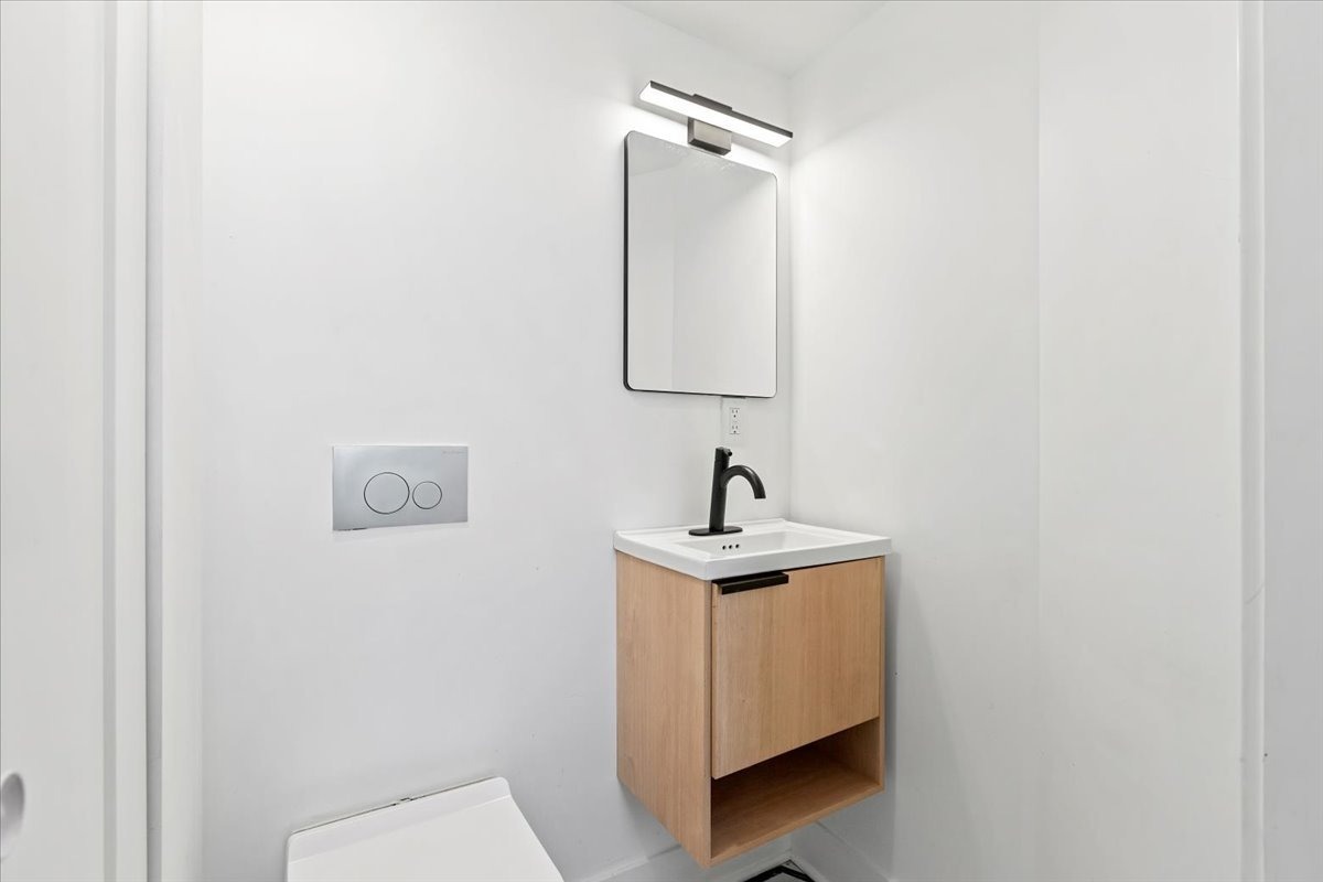 449 North Elizabeth Street, Unit 3S Chicago, IL 60642 - Photo 11 of 12 a bathroom with a toilet a sink and mirror