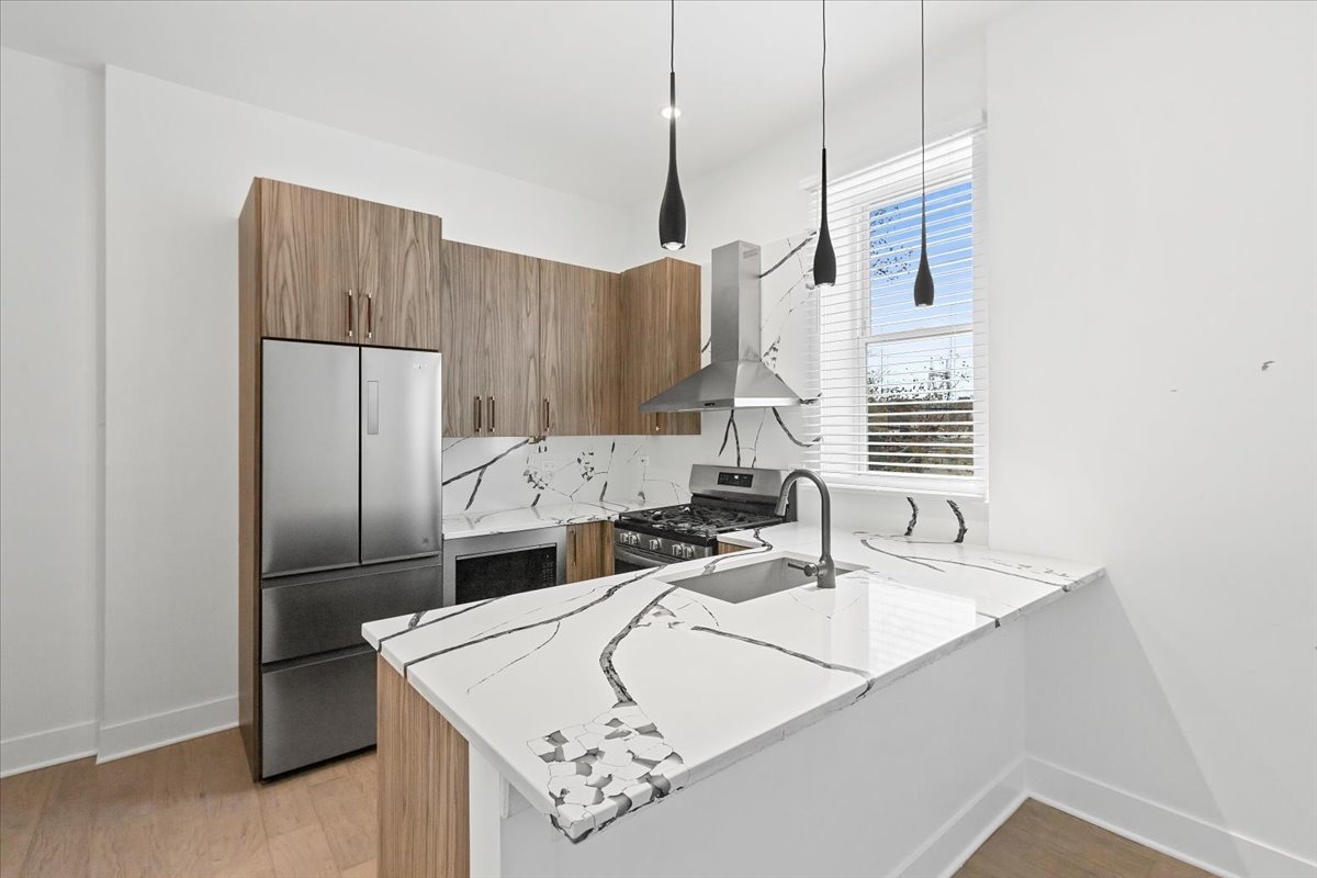 449 North Elizabeth Street, Unit 3S Chicago, IL 60642 - Photo 3 of 12 a kitchen with kitchen island a sink stove and refrigerator
