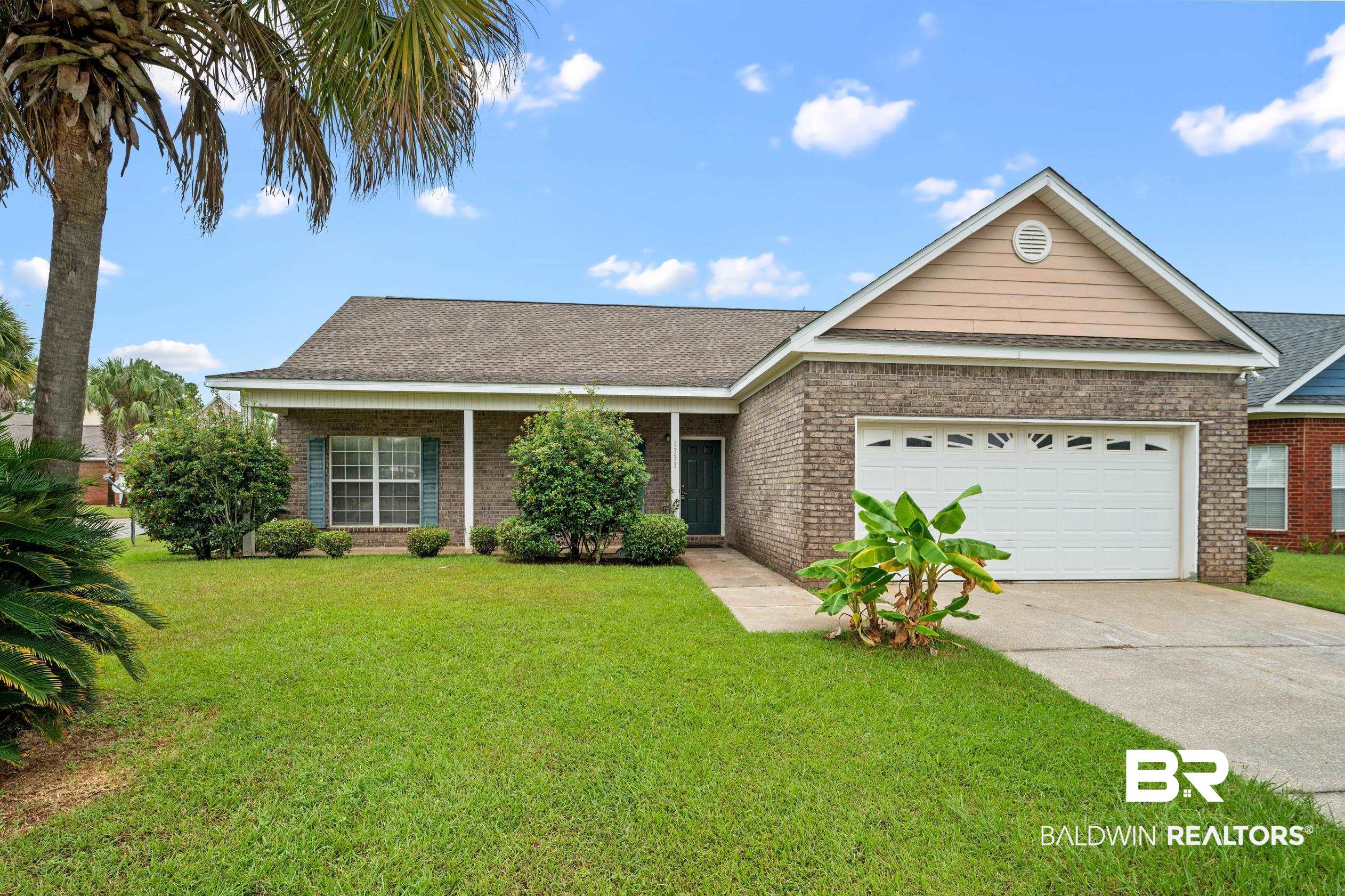 Ranch-style house with a garage and a front lawn
