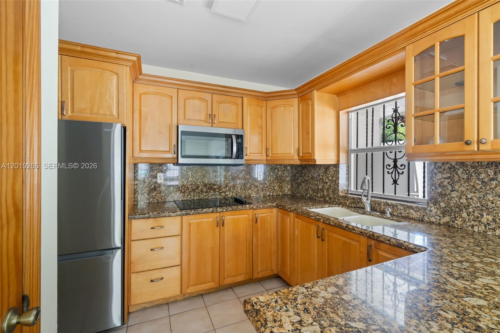 13 Southwest 97th Place Miami, FL 33174 - Photo 12 of 29 a kitchen with granite countertop a refrigerator and cabinets