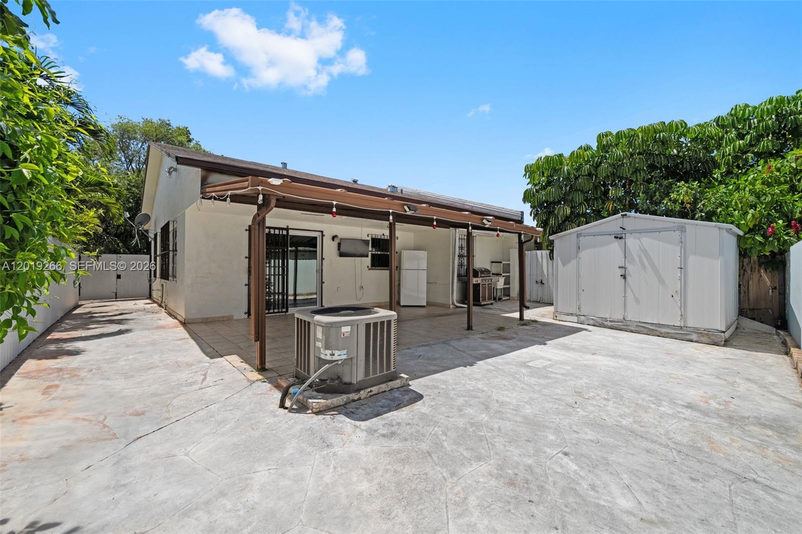13 Southwest 97th Place Miami, FL 33174 - Photo 25 of 29 a backyard of a house with table and chairs and potted plants