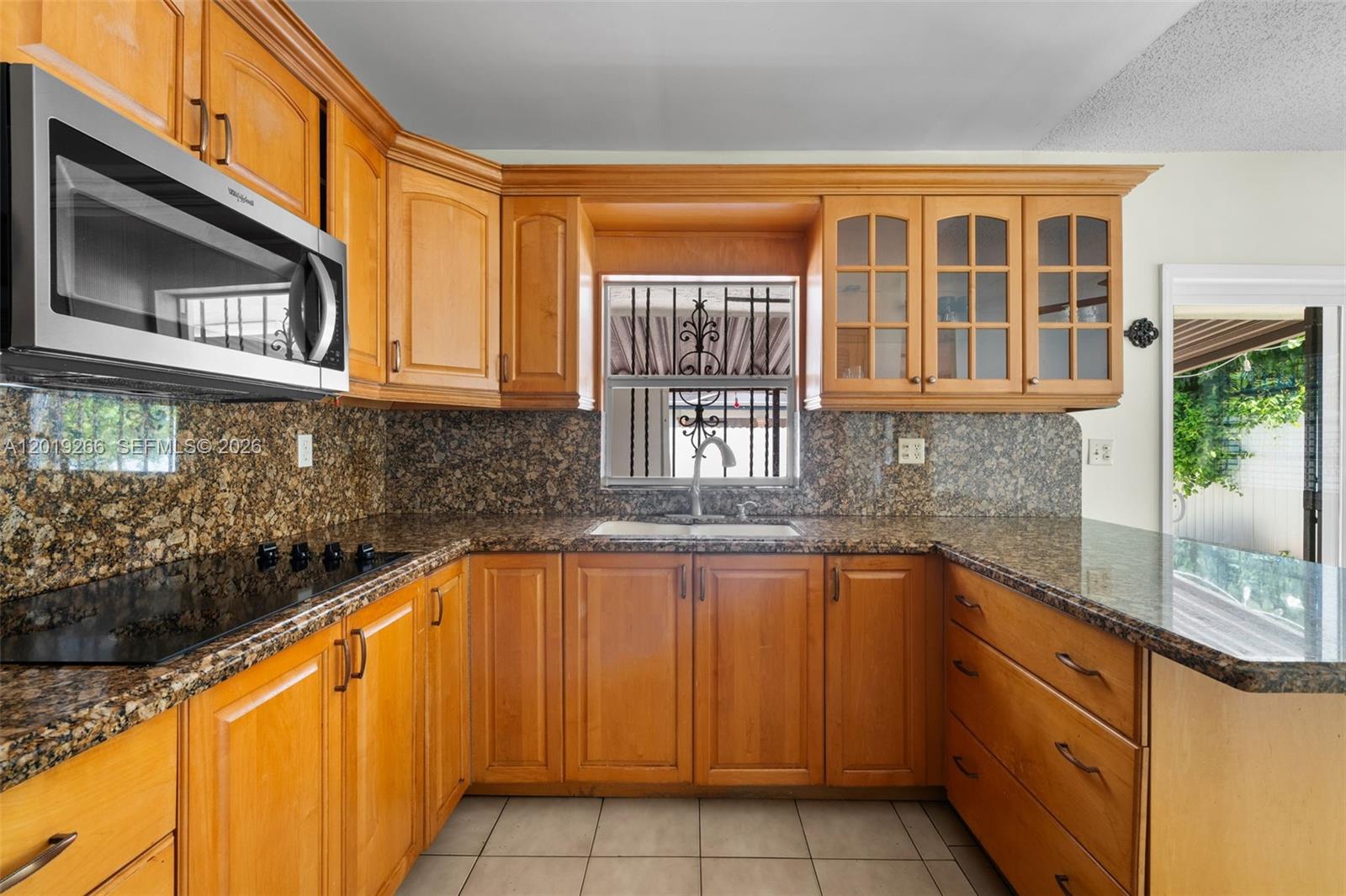 13 Southwest 97th Place Miami, FL 33174 - Photo 10 of 29 a kitchen with stainless steel appliances granite countertop a sink and dishwasher a stove top oven with wooden floor
