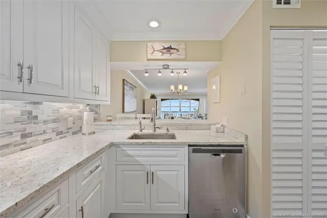 a kitchen with a sink dishwasher and cabinets with wooden floor