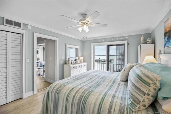 a bedroom with a large bed a flat tv screen and a chandelier