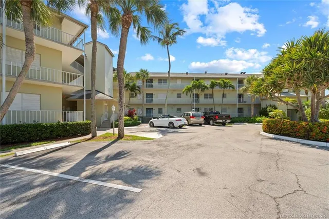 an aerial view of a city with lots of residential buildings ocean and mountain view in back