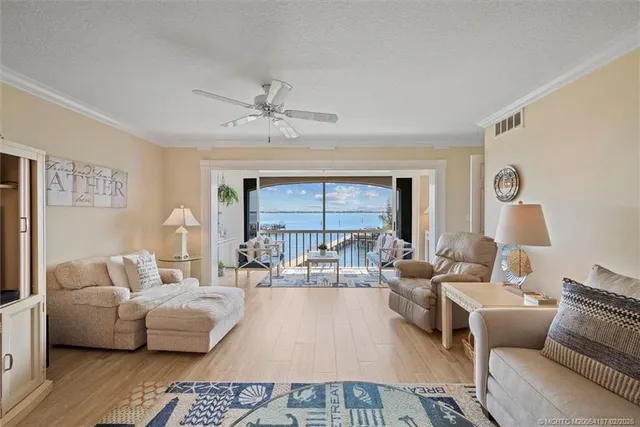 a living room with furniture a chandelier and a large window